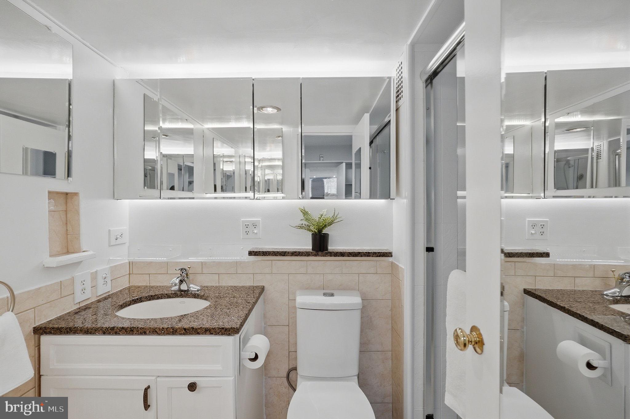 3001 Veazey Street Northwest, Unit 116 Washington, DC 20008 - Photo 17 of 40 a bathroom with a granite countertop sink and a mirror