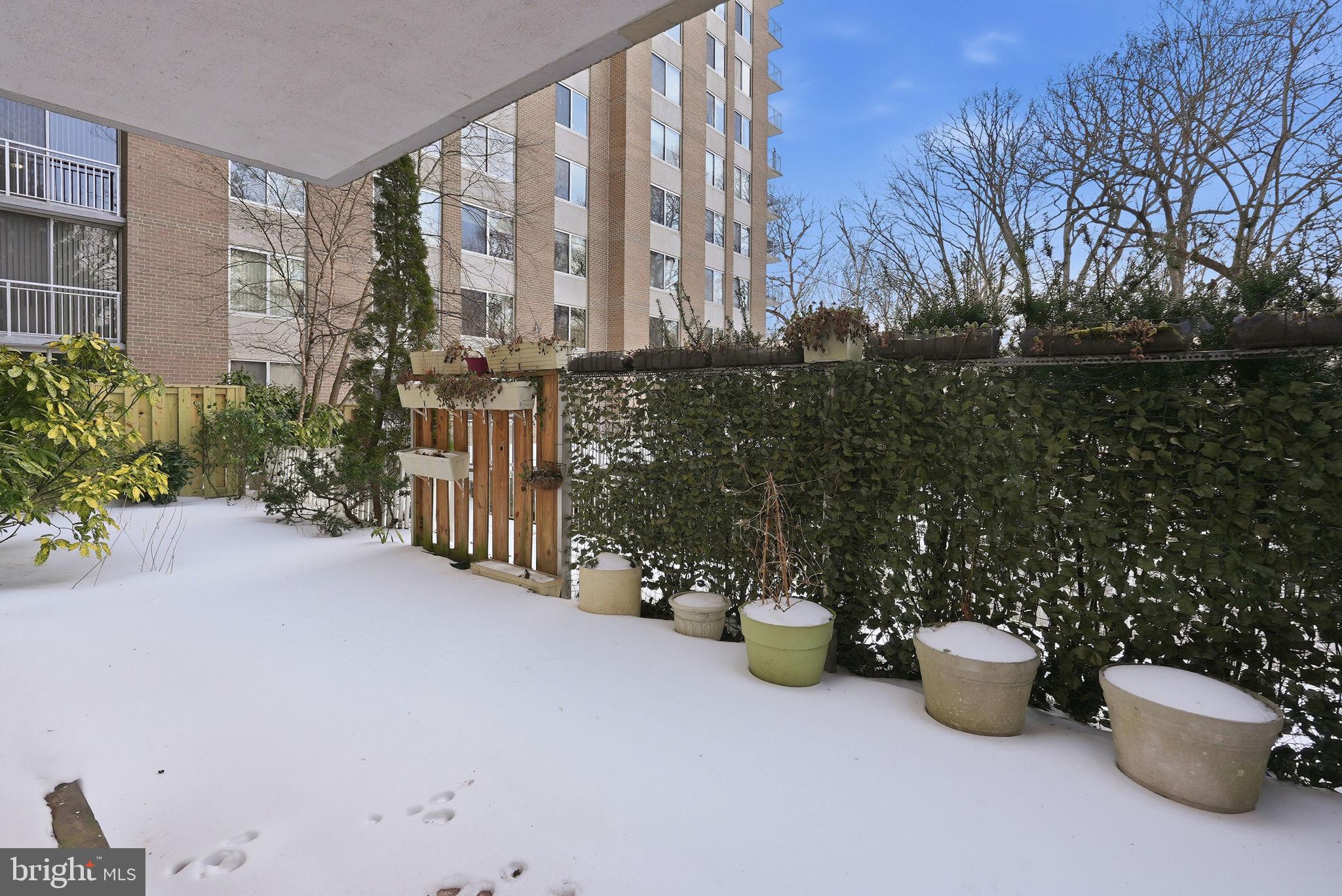 3001 Veazey Street Northwest, Unit 116 Washington, DC 20008 - Photo 6 of 40 a view of a patio with dining table and chairs potted plants
