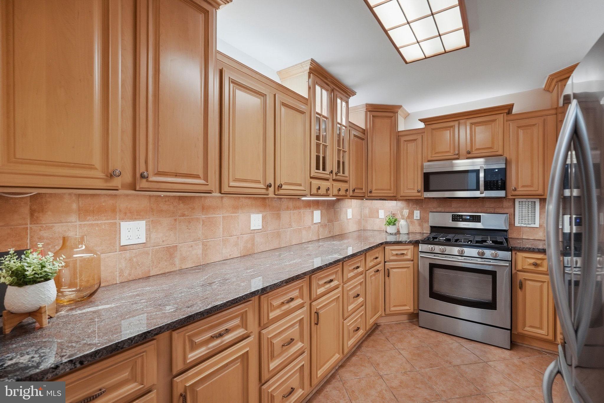 3001 Veazey Street Northwest, Unit 116 Washington, DC 20008 - Photo 9 of 40 a kitchen with stainless steel appliances granite countertop a stove a sink and a microwave