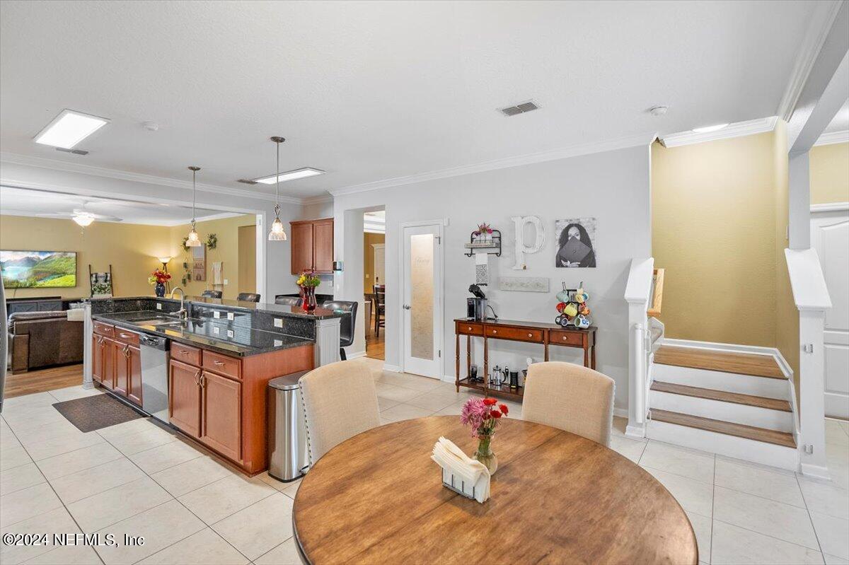 16402 Tisons Bluff Road Jacksonville, FL 32218 - Photo 16 of 45 a kitchen with stainless steel appliances kitchen island granite countertop a table and chairs in it