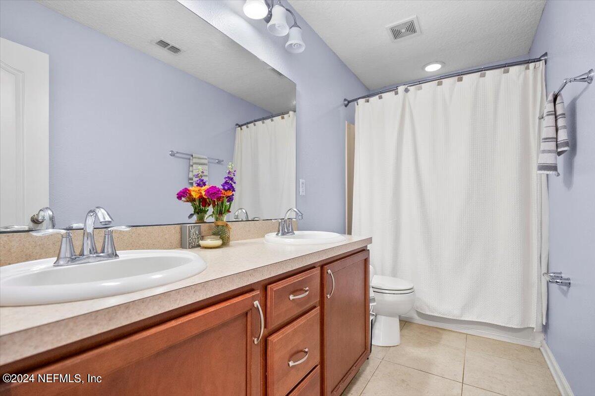 16402 Tisons Bluff Road Jacksonville, FL 32218 - Photo 21 of 45 a bathroom with a granite countertop sink a toilet and a mirror