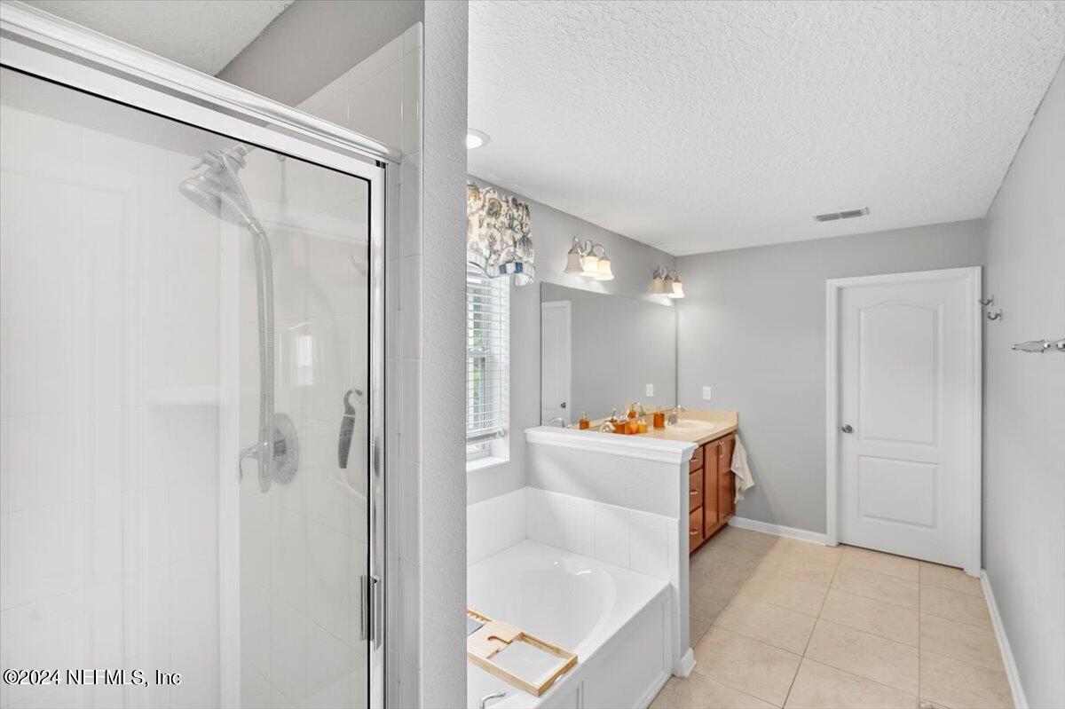 16402 Tisons Bluff Road Jacksonville, FL 32218 - Photo 24 of 45 a bathroom with a tub sink vanity and mirror