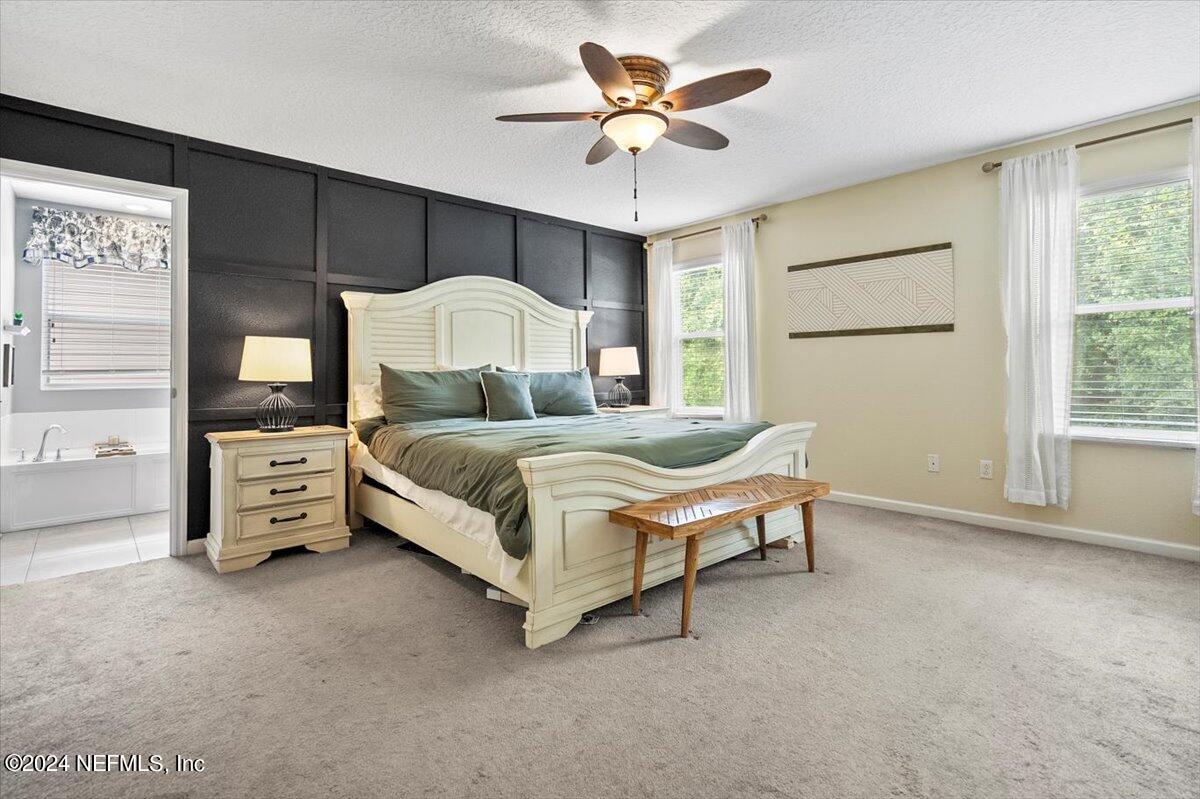 16402 Tisons Bluff Road Jacksonville, FL 32218 - Photo 28 of 45 a bedroom with a bed and a chandelier