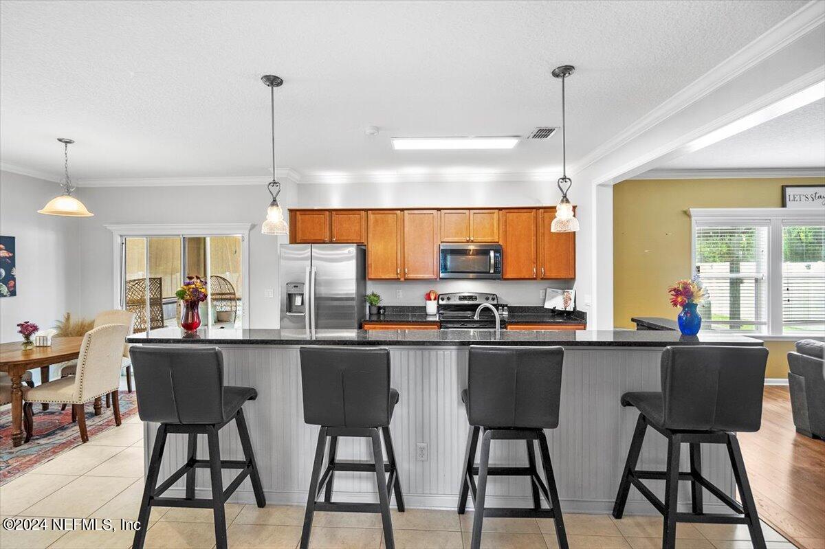 16402 Tisons Bluff Road Jacksonville, FL 32218 - Photo 8 of 45 a kitchen with stainless steel appliances a dining table chairs and white cabinets