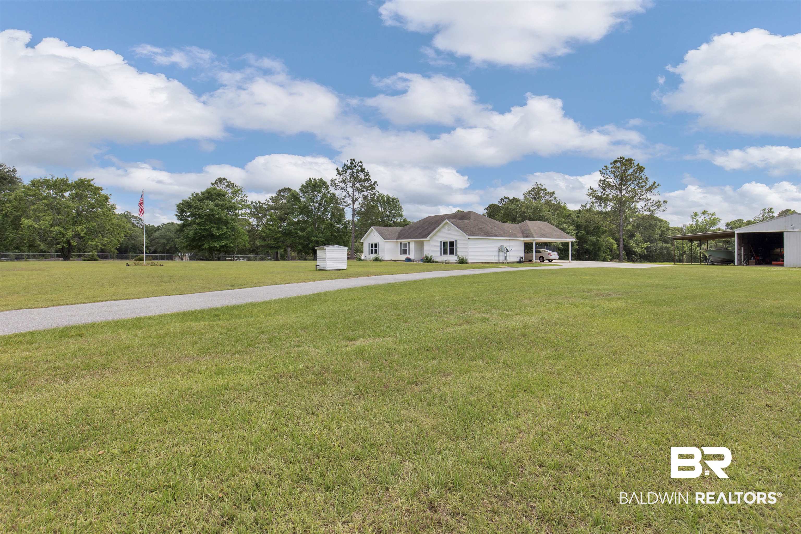 13925 Fort Lake Road Grand Bay, AL 36541 - Photo 3 of 37 View of yard featuring a storage unit, a carport, an outdoor structure, and driveway