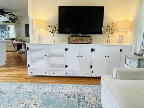a living room with table and flat screen tv