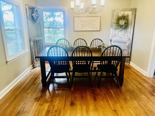 a dining room with furniture a chandelier and wooden floor