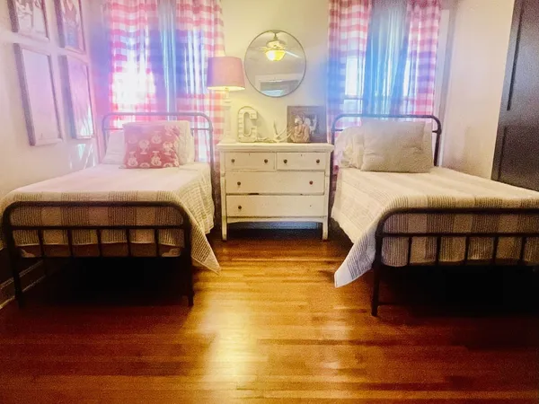 a bedroom with a bed wooden floor and window