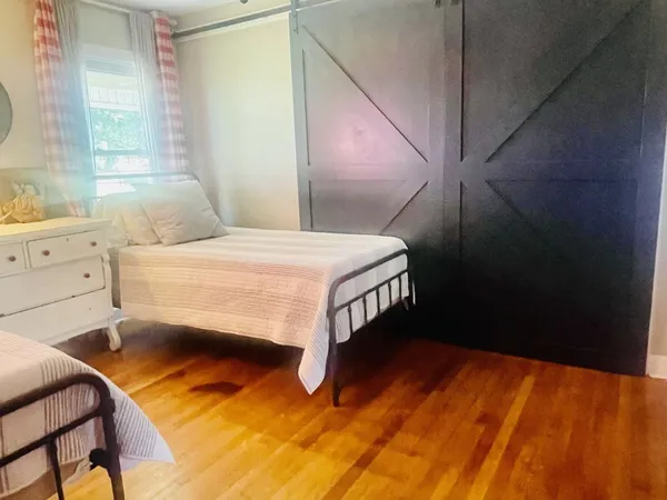 a bedroom with a bed and a dresser next to a window