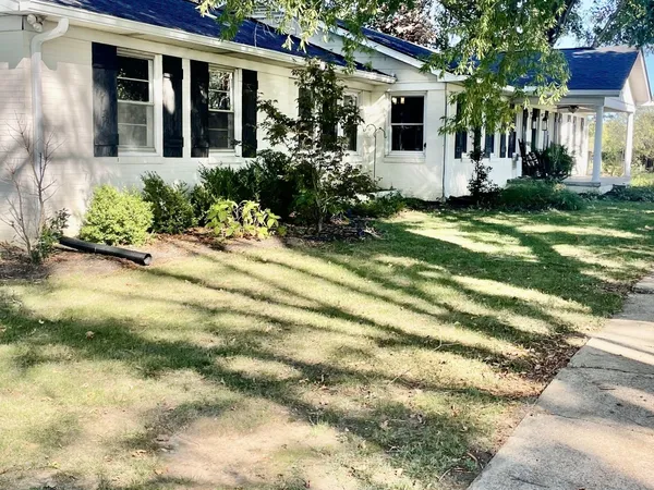 a view of a house with backyard and sitting area