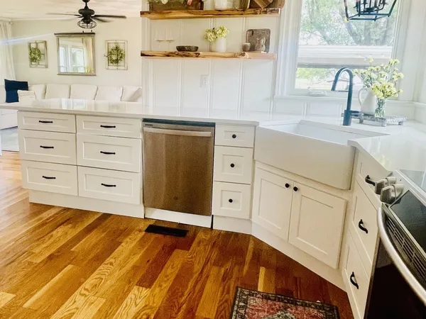 a view of a sink and dishwasher with wooden floor