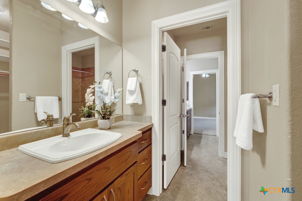7607 Sky Loop Garden Ridge, TX 78266 - Photo 34 of 43 a en suite bathroom with a sink double vanity and a mirror