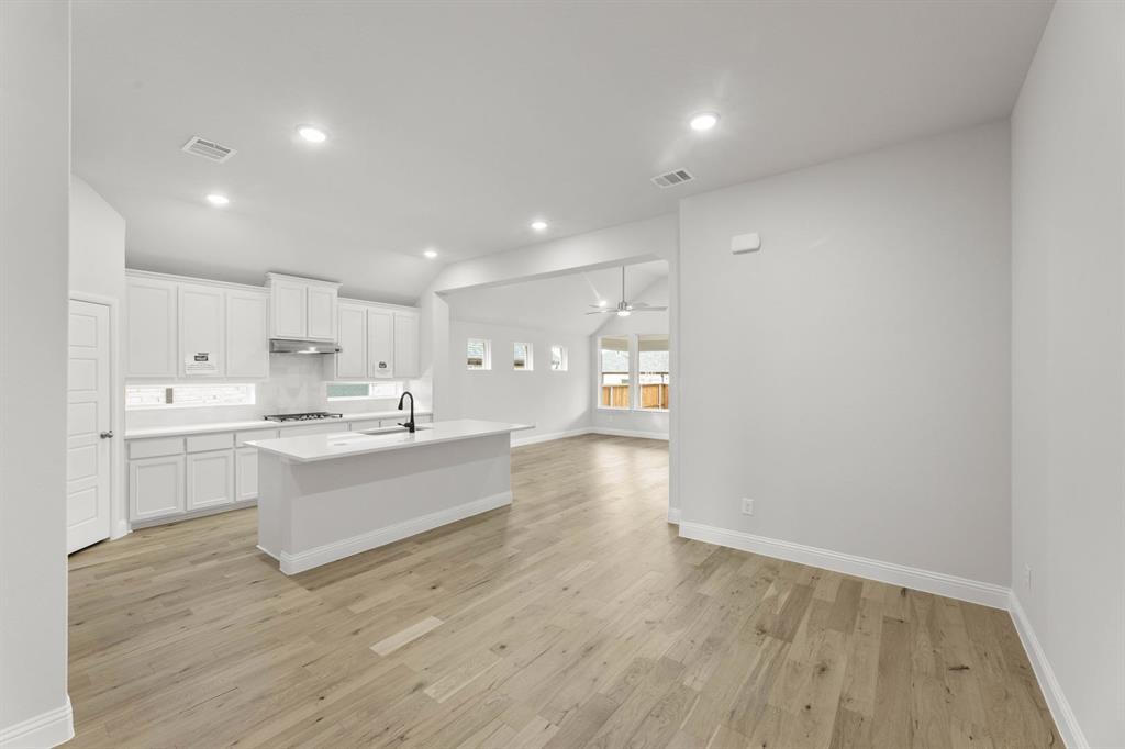14422 Mietner Street Pilot Point, TX 76258 - Photo 8 of 23 a large white kitchen with wooden floors and view living room