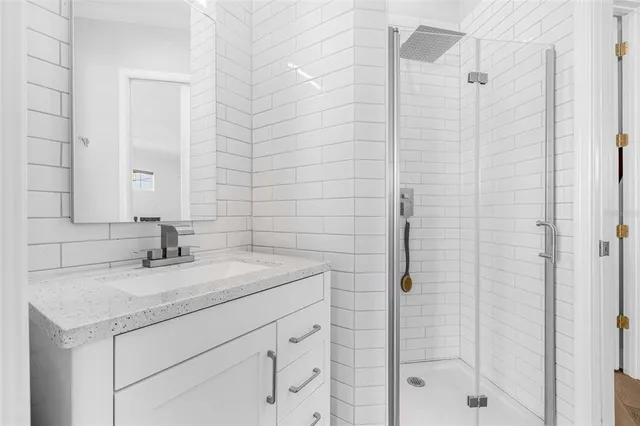 a bathroom with a sink vanity and shower