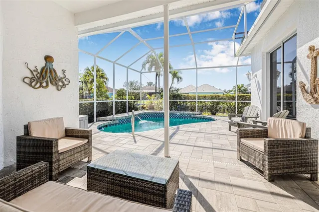 a living room with patio furniture and a floor to ceiling window