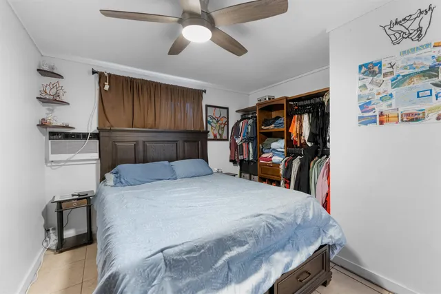 a bedroom with a bed a large window and flat screen tv