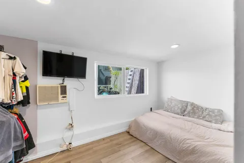 a bedroom with a bed and a flat screen tv