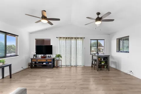 a view of a livingroom with furniture window wooden floor and a ceiling fan
