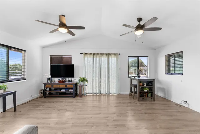 a view of a livingroom with furniture window wooden floor and a ceiling fan