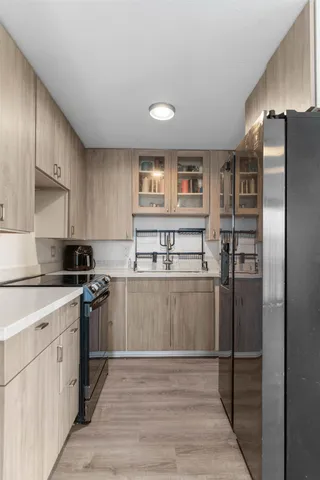 a kitchen with stainless steel appliances granite countertop a refrigerator and a stove top oven