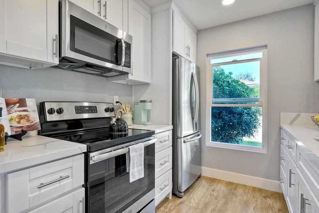 858 South Rancho Santa Fe Road, Unit D San Marcos, CA 92078 - Photo 1 of 1 a kitchen with stainless steel appliances granite countertop a stove a microwave and a white cabinets