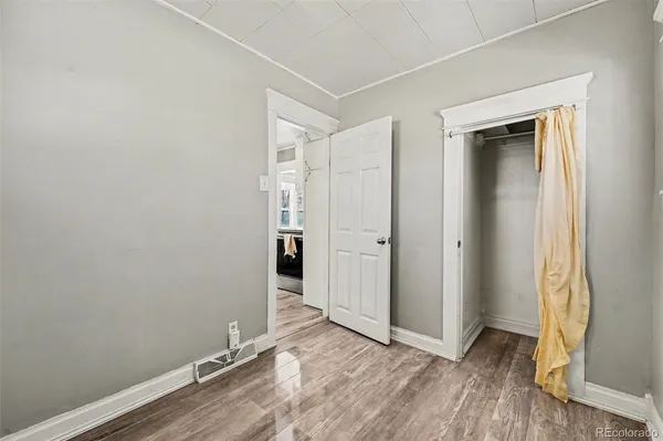 an empty room with wooden floor and closet