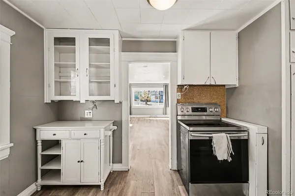 a kitchen with white cabinets and appliances