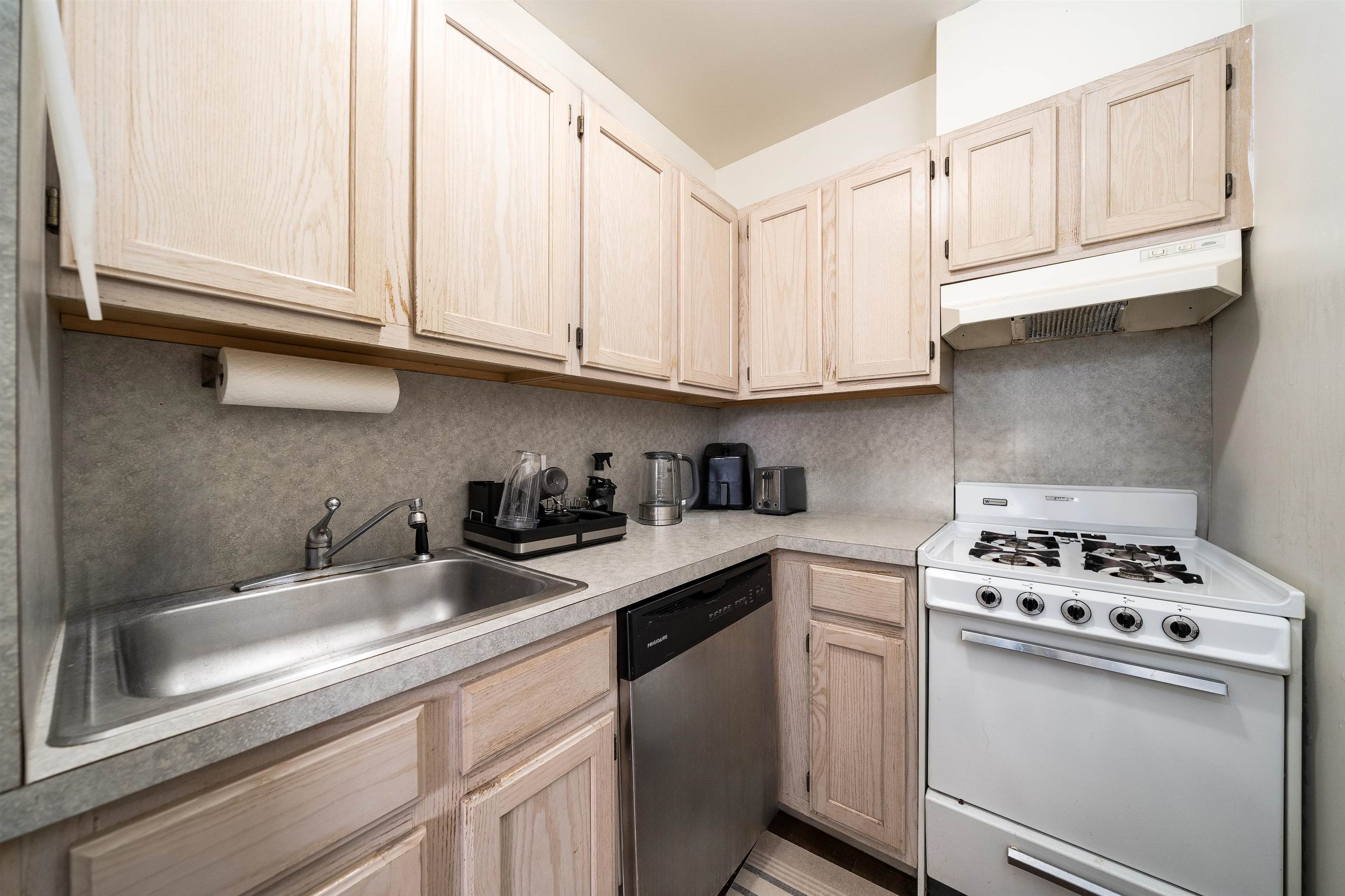 461 4th Street, Unit 3W Hoboken, NJ 07030 - Photo 7 of 12 a kitchen with granite countertop white cabinets and white appliances