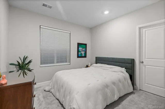 a bedroom with a large bed and a potted plant