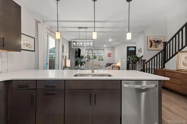 a kitchen with stainless steel appliances granite countertop a sink a island a stove and a wooden floor