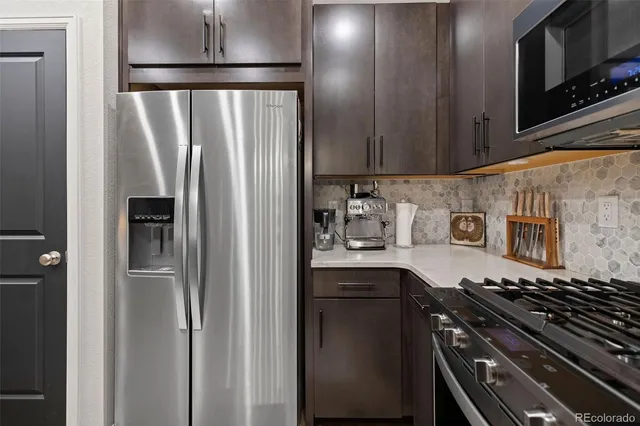 a kitchen with stainless steel appliances granite countertop a refrigerator and a sink