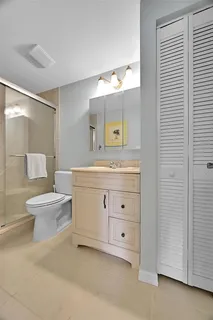 a bathroom with a double vanity sink a toilet and a mirror
