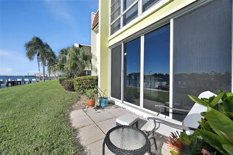 a patio with table and chairs and potted plants
