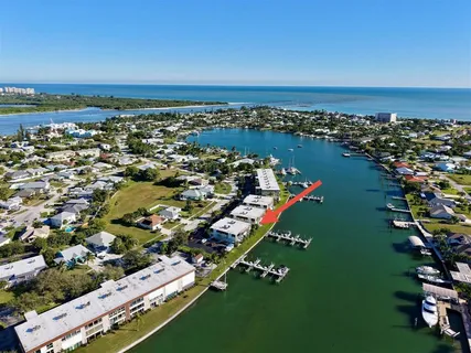 an aerial view of a city with lots of residential buildings ocean and mountain view in back