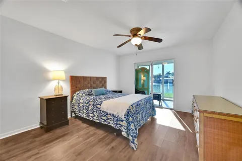 a bedroom with a bed chandelier and a window