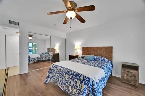 a bedroom with a large bed chandelier and a window