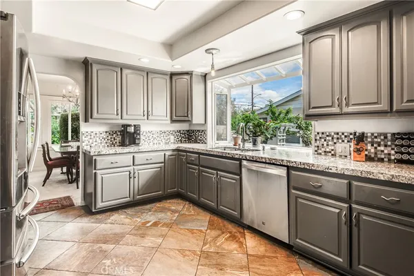 a kitchen with a sink window and cabinets