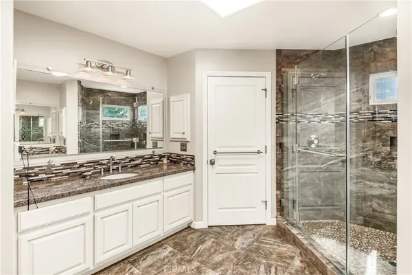 a bathroom with a shower sink and mirror
