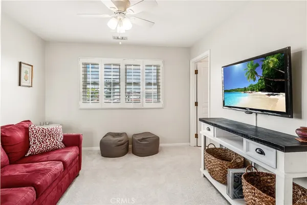 a living room with furniture a flat screen tv and a window