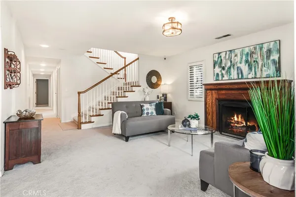 a living room with furniture a fireplace and a potted plant