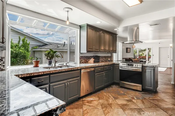 a kitchen with stainless steel appliances granite countertop a stove sink and cabinets