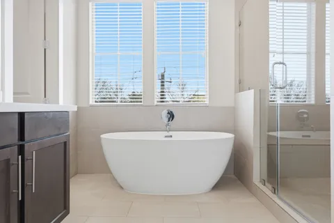 a white bath tub sitting in a bathroom next to a window