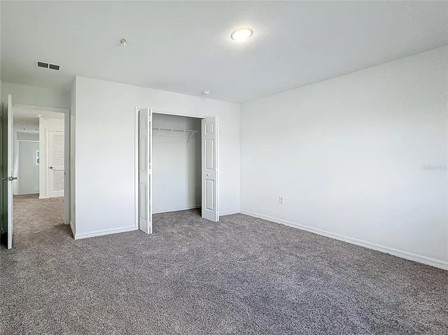a view of an empty room with closet area