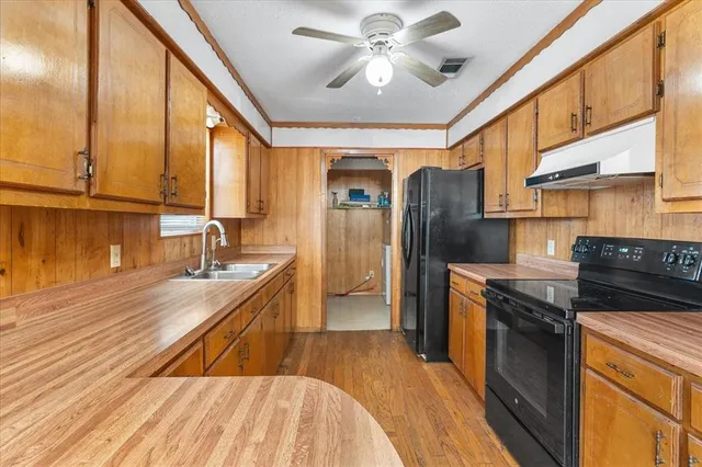 a kitchen with stainless steel appliances granite countertop a sink a stove and refrigerator