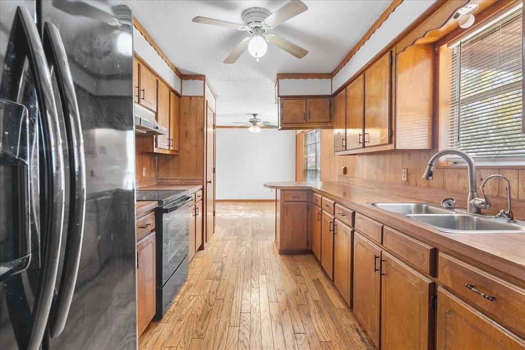 519 Tolson Avenue Van Alstyne, TX 75495 - Photo 6 of 25 a kitchen with stainless steel appliances granite countertop a refrigerator a sink dishwasher a stove and white countertops with wooden floor