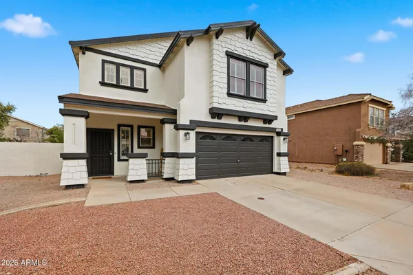 a front view of a house with yard and parking