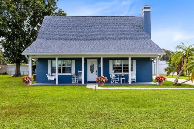 a view of a house with a yard and sitting area
