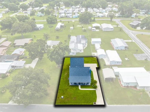 an aerial view of a house with swimming pool having outdoor seating