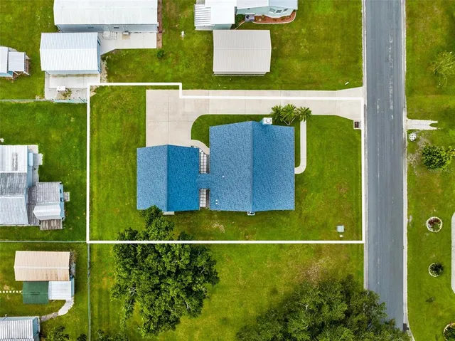 an aerial view of residential houses with outdoor space and parking