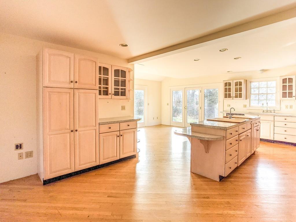 678 Point Road Marion, MA 02738 - Photo 8 of 33 a large living room with kitchen island granite countertop wooden floor and white walls